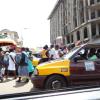 Cars and people share the road. Cars beep twice to warn that they are not stopping.